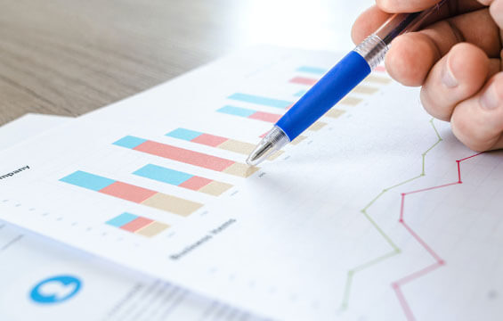 Consultant reviewing performance charts with a pen in hand